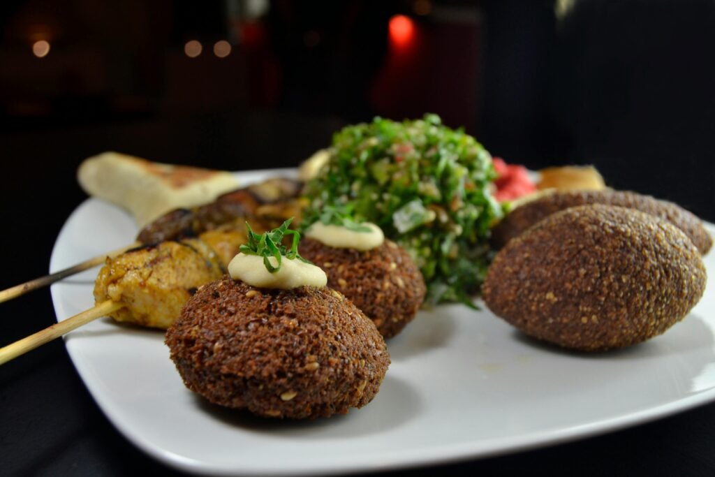 A vibrant Middle Eastern dish with falafel, kebabs, tabbouleh on a plate.